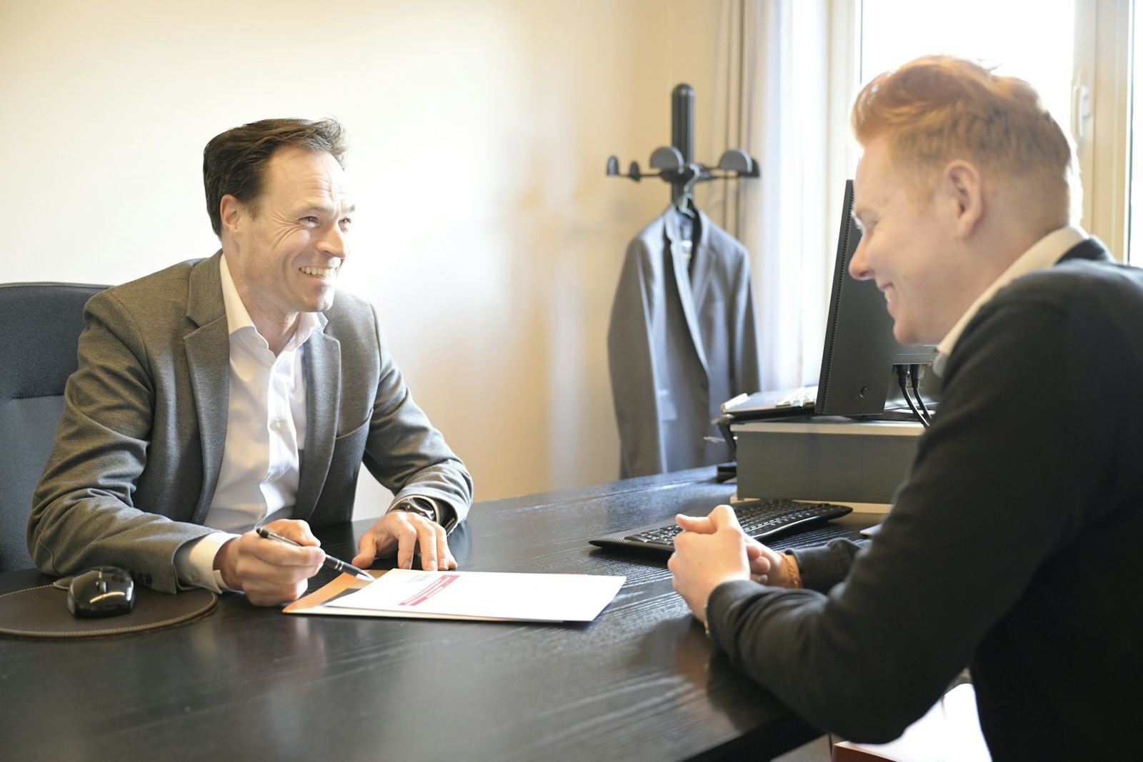 Two executives in conversation across a desk